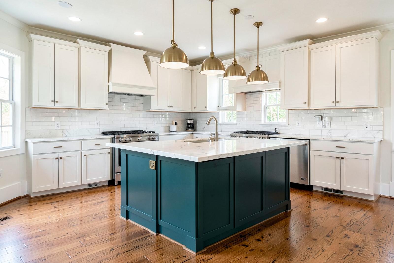 Remodeled kitchen with white cabinets, teal island and brass pendant lights
